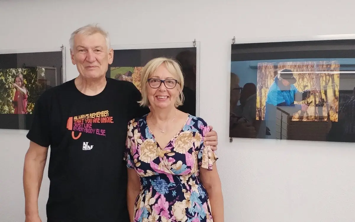 Obiskovalci si v avli Jožeta Hudalesa Občine Lenart ogledujejo razstavljena fotografska in likovna dela na temo vinogradov, trte in narave.