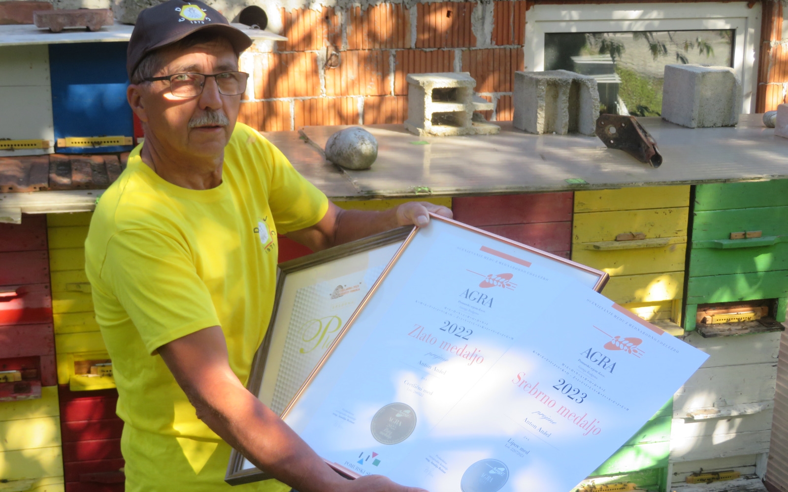 Zvonko Anžel z diplomami in priznanji za med, ki so ga nabrale njegove prijateljice – čebele.