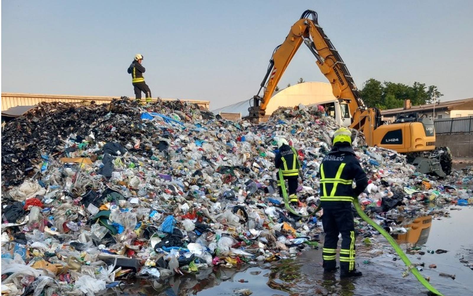 Na požarišču ostaja požarna straža in dva stroja, ki prelagata bale, saj pod njimi še vedno tli. Foto: Franc Krivec.